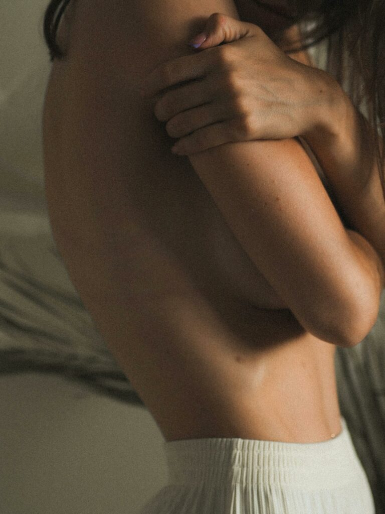 kvindekrop-fra-siden-med-arme-over-bryst