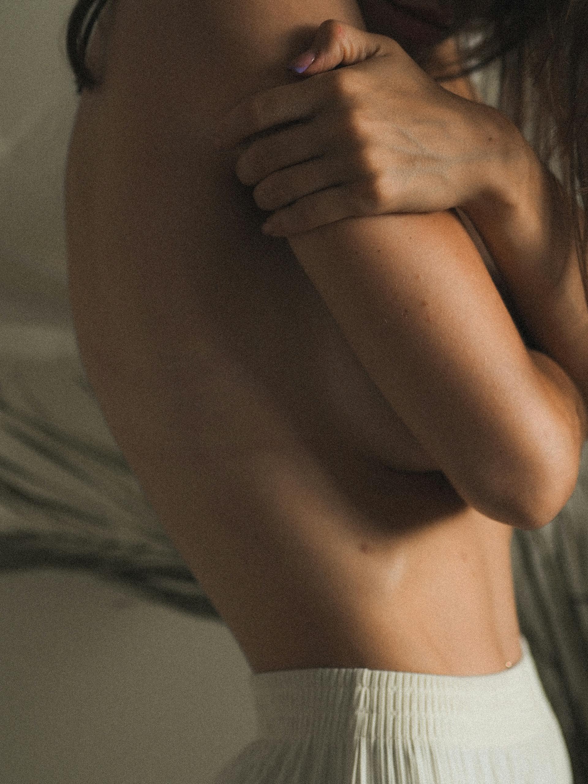 kvindekrop-fra-siden-med-arme-over-bryst